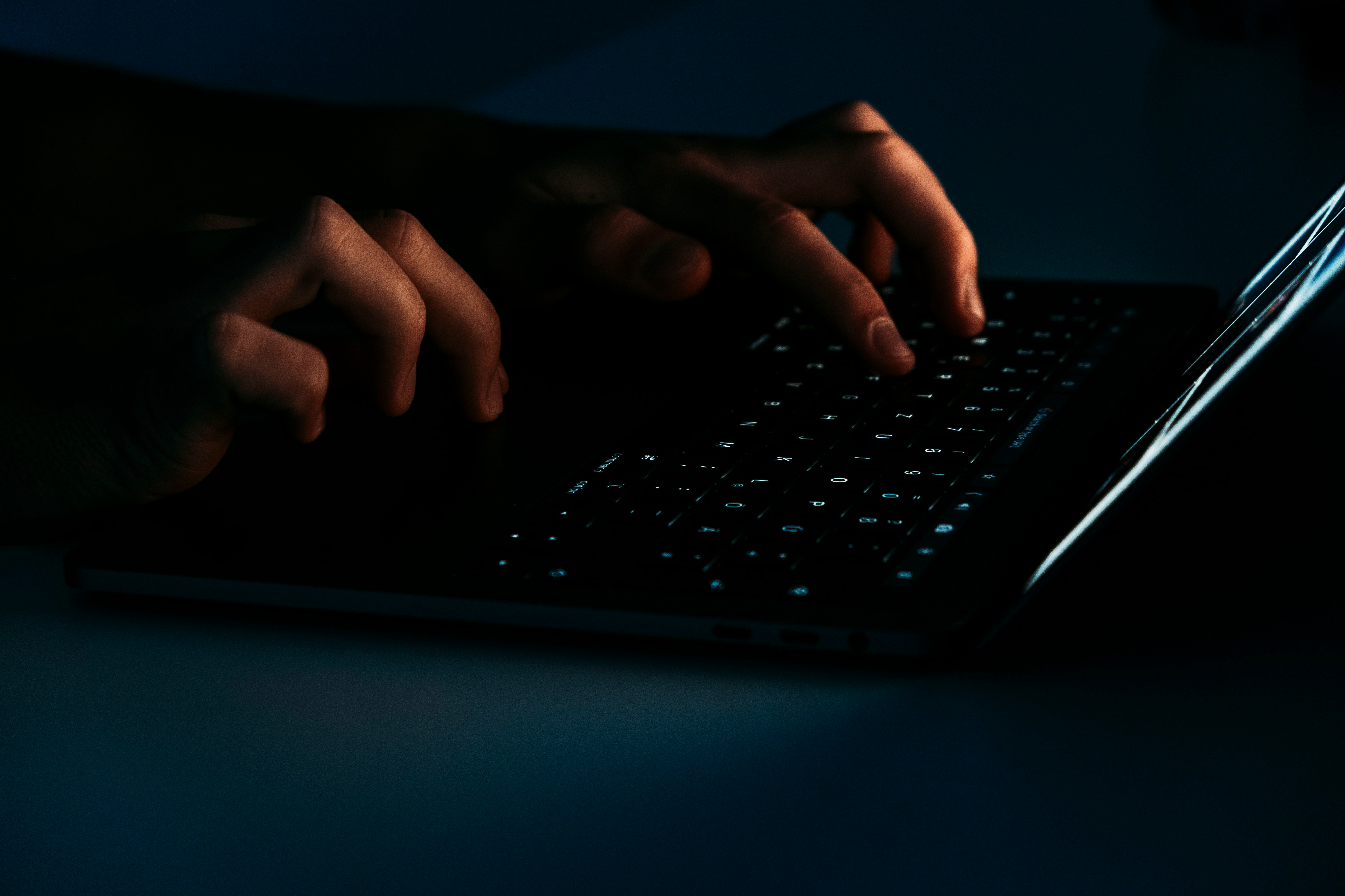 A person looking warily at an email attachment on a laptop