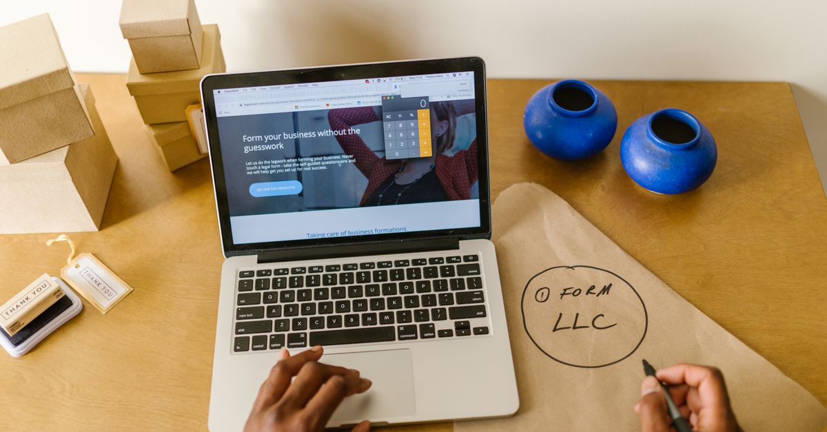 A small business workspace with a laptop, packaging, and handwritten startup notes